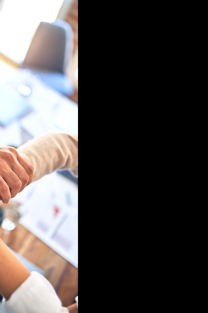 Several diverse hands join together in a gesture of teamwork and collaboration.