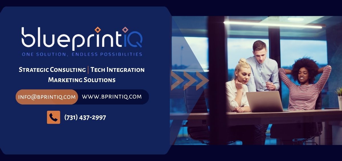 Four people collaborating at a laptop in a modern office setting.