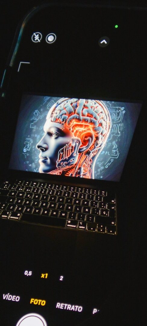 Computer AI Head A laptop displaying a digital illustration of a human head with neural pathways.